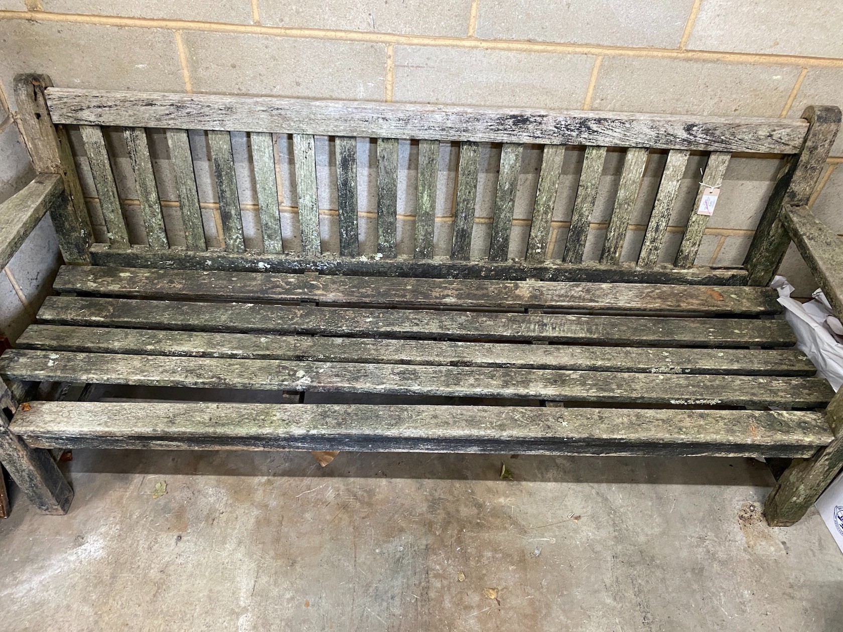 A weathered teak garden bench, length 194cm, height 83cm (a.f.)